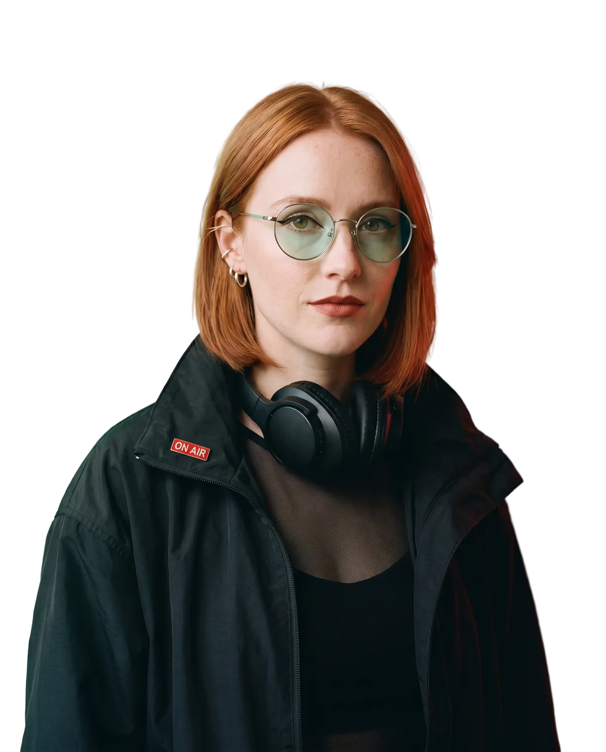 Margot, an AI-generated character: copper-red jaw-length bob, round mint-tinted glasses, silver hoops, black high-collar jacket, red ON AIR pin.